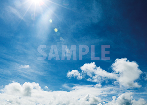 日光が降り注ぐ青空と白い雲のA4サイズ背景素材